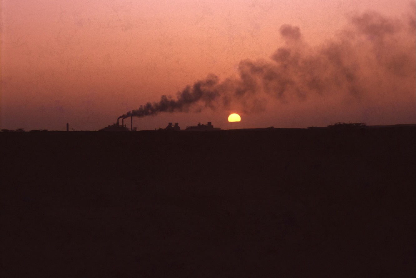 Sunset over beach with cement plant in the background