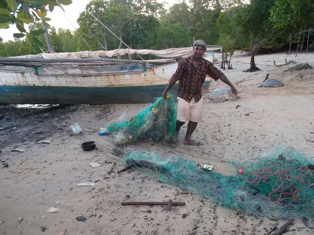 A community member removes a confiscated fishing net in Berafia